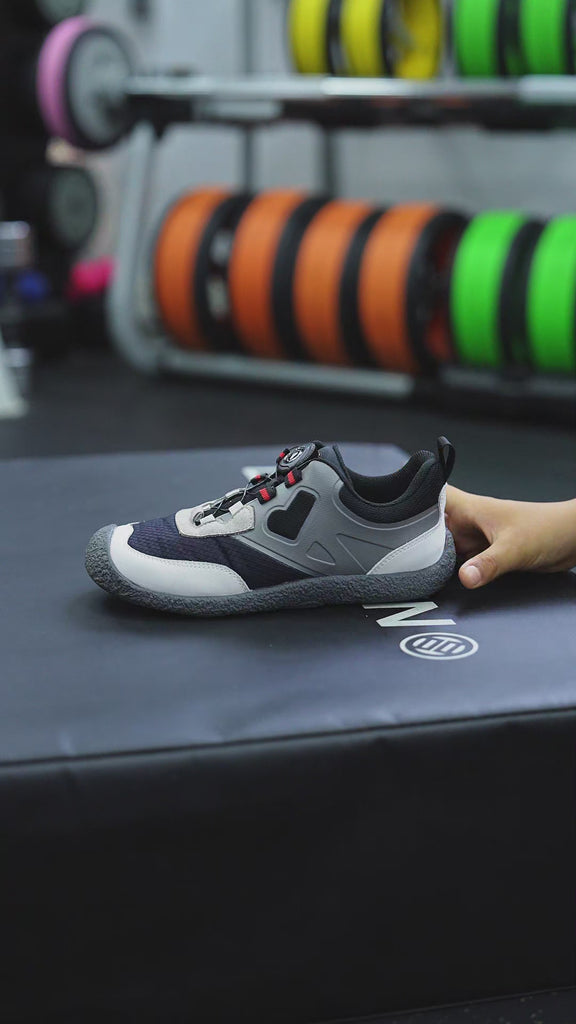 A kid is wearing and testing a pair of Barefoot Kids Trainers by Little Blue Lamb